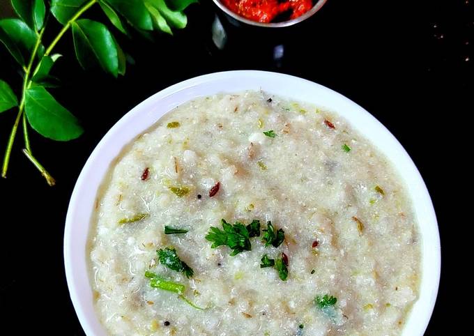 A steaming bowl of rice gruel with fresh herbs and spices, a comforting and healthy meal.